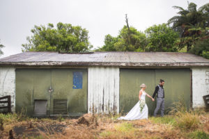 Groom leads his Bride alongside a rustic barn